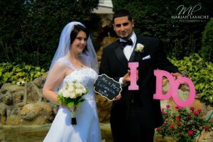 couple smiling holding signs and letters that say I DO