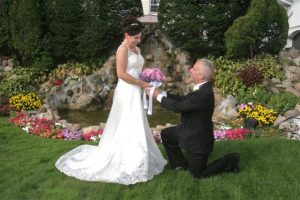 man down on one knee facing bride