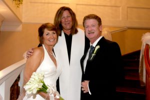 couple smiling with officiant