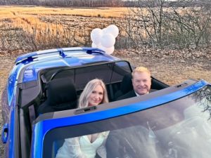 couple in blue convertible for drive thru wedding