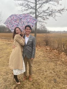 happy couple holding an umbrella after drive thru wedding