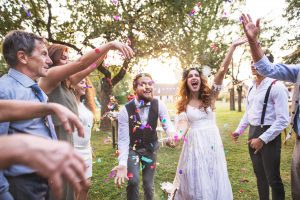 couple getting confetti thrown at them during their backyard wedding
