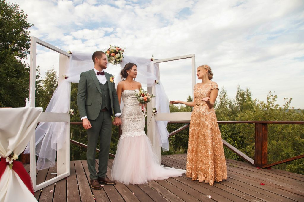 woman wedding officiant marrying couple at the altar