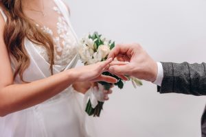 groom putting ring on brides finger