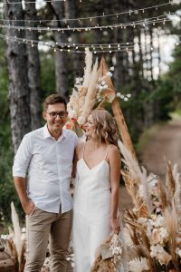 wedding ceremony of the marriage of a guy and a girl against the backdrop of an arch on a forest path