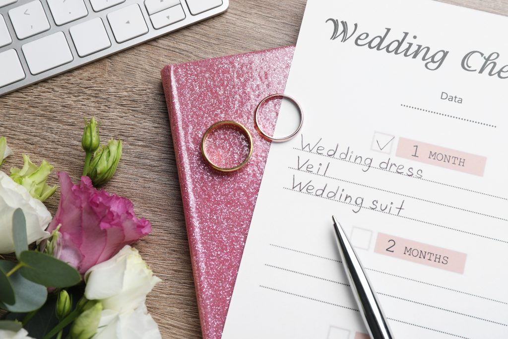 Flat lay composition with Wedding Checklist and planner on wooden table