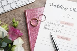 Flat lay composition with Wedding Checklist and planner on wooden table