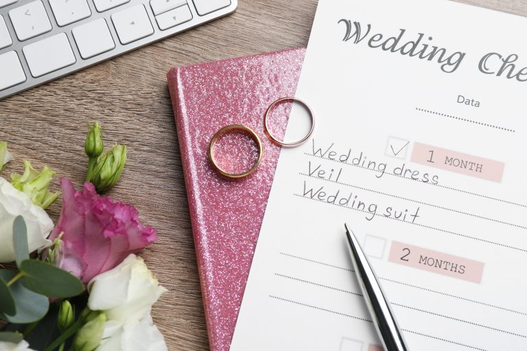 Flat lay composition with Wedding Checklist and planner on wooden table
